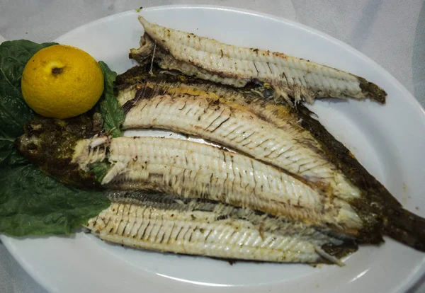 Bodegón con pescado a la parrilla y limón — Foto de Stock