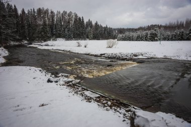 Moskova yakınlarındaki bir nehir ve kabarık karla kaplı bankaları ile manzara 