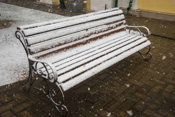 A bench smoothly covered with fresh snow after weather phenomena — Stock Photo, Image