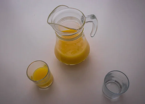 Bodegón con jarra, dos vasos y zumo de naranja — Foto de Stock