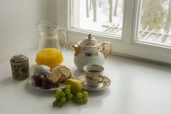 Still life with  Easter cakes, eggs, teapot and a cup of  tea juice — Stock Photo, Image