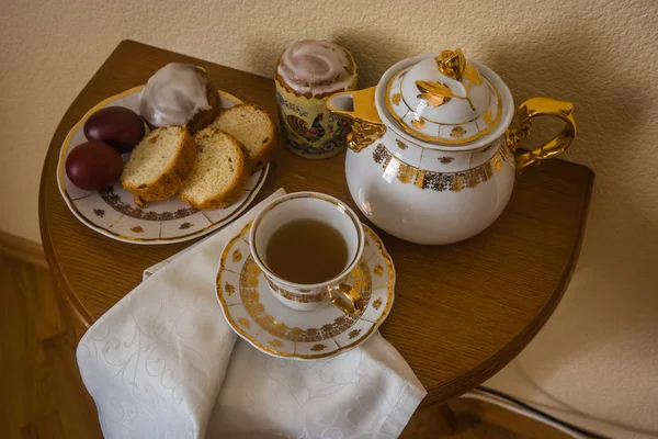 Натюрморт с пасхальными тортами, яйцами, чайником и чашкой чая — стоковое фото