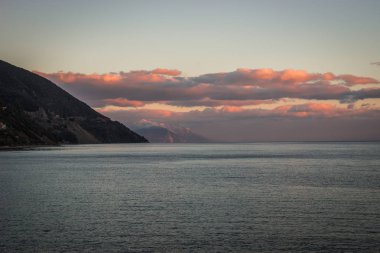 Gün batımı ve pembe bulutlar denize Loutra Edipsou, Yunanistan