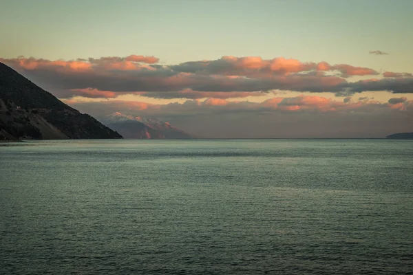 Puesta de sol y nubes rosadas sobre el mar en Loutra Edipsou, Grecia — Foto de Stock