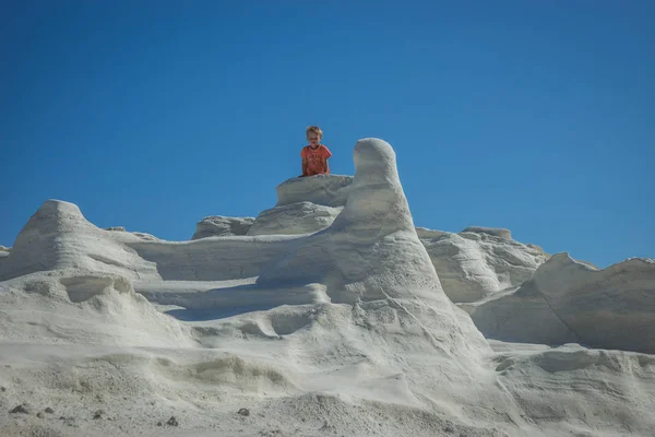 Маленький мальчик прогуливается по пляжу Moonscape Sarakiniko, Милош, Греция — стоковое фото