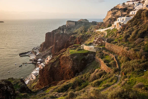 White city on a slope of a hill at sunset, Oia, Santorini, Greece