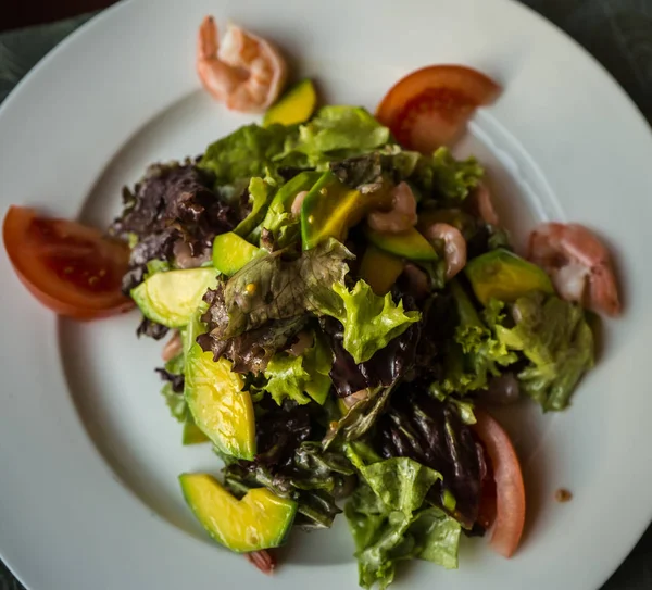 Foglie di insalata con frutti di mare, avocado e pomodori, focus selettivo — Foto Stock