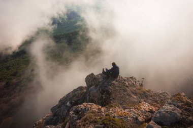 Kırım 'daki Ai Petri Dağı' nda bulutlardaki insan silüeti ve sisle kaplı bir manzara.