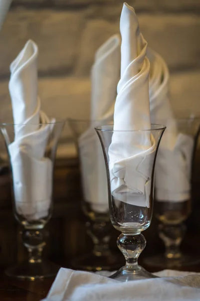 Copos de vinho em uma mesa de madeira com fraldas brancas — Fotografia de Stock