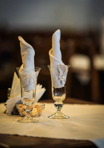 Copos de vinho em uma mesa de madeira com fraldas brancas — Fotografia de Stock
