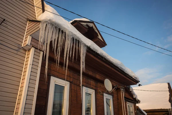 Παγωμένη icicles στη στέγη των σπιτιών το ρωσικό χειμώνα — Φωτογραφία Αρχείου