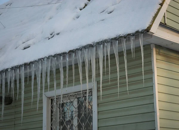 Παγωμένη icicles στη στέγη των σπιτιών το ρωσικό χειμώνα — Φωτογραφία Αρχείου