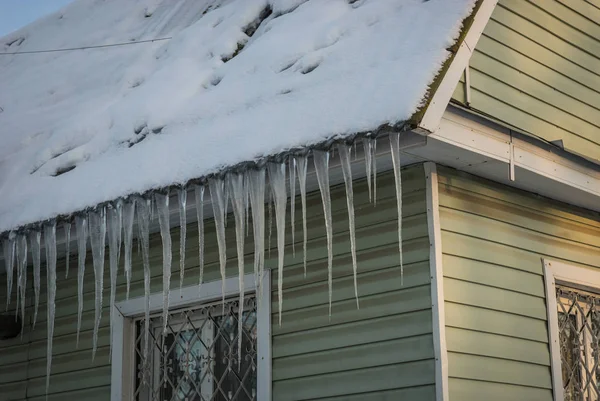 Παγωμένη icicles στη στέγη των σπιτιών το ρωσικό χειμώνα — Φωτογραφία Αρχείου