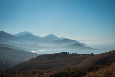 Deniz manzarası ve sis Girit Adası dağlarda