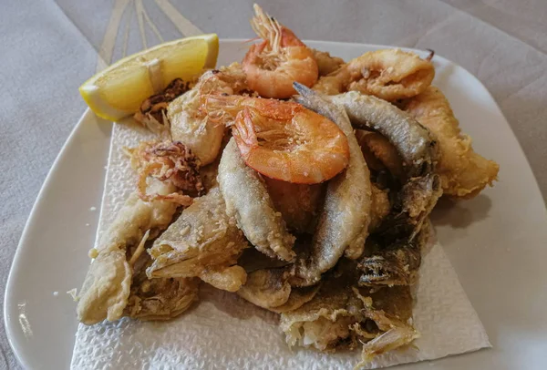 Karışık deniz ürünleri ve limonlu balıklar beyaz tabakta. — Stok fotoğraf