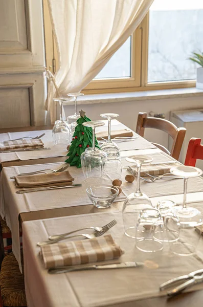 Mesa de cena con un pequeño árbol de Navidad y nueces espolvoreadas , — Foto de Stock