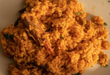 Beyaz tabakta deniz ürünü ve karidesli kırmızı risotto