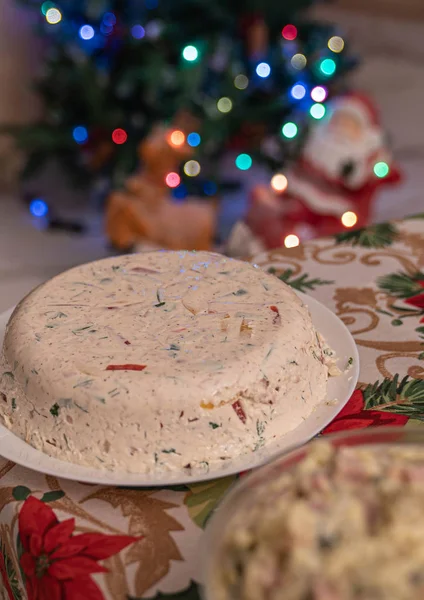 Christmas tuna jelly salad on a white plate with lights on the b — Stock Photo, Image