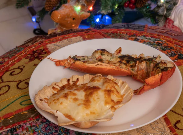 Baked scallop and lobster on a white plate with New Year's light — Stock Photo, Image
