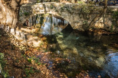 Yunanistan 'ın Livadia kentinde nehir ve köprüyle sonbahar manzarası