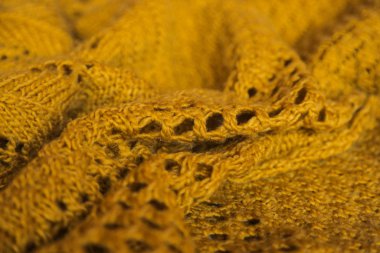 Orange knitted background. Close up gray fabric texture background. wrinkled and shadows, selective focus top view