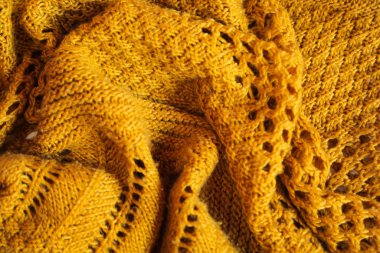 Orange knitted background. Close up gray fabric texture background. wrinkled and shadows, selective focus top view