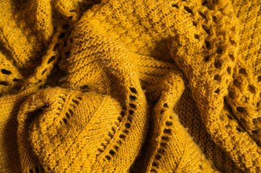 Orange knitted background. Close up gray fabric texture background. wrinkled and shadows, selective focus top view
