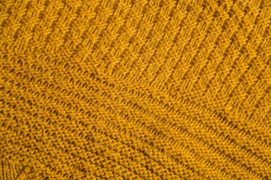 Orange knitted background. Close up gray fabric texture background. wrinkled and shadows, selective focus top view