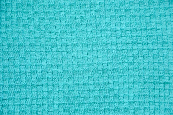 turquoise knitted background. Close up gray fabric texture background. wrinkled and shadows, selective focus top view