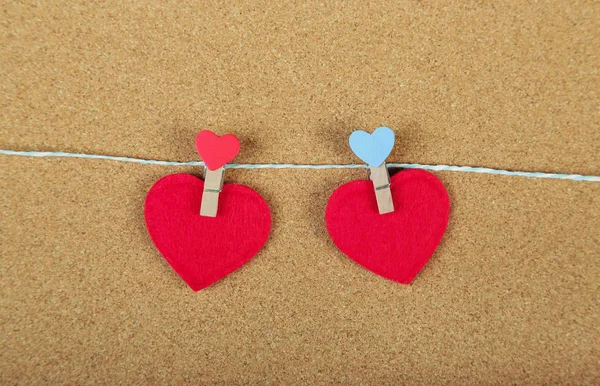 Tarjeta de felicitación para el día de San Valentín. Corazones rojos en la cuerda con pinzas de ropa, sobre fondo de madera. Copiar espacio. Puesta plana — Foto de Stock