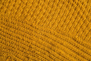 Orange knitted background. Close up gray fabric texture background. wrinkled and shadows, selective focus top view