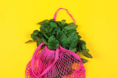 Sarı arka planda yeniden kullanılabilir yeşil poşetler. Pamuk alışveriş torbası. Sıfır atık, plastiksiz konsept. Üst manzara, düz uzanma