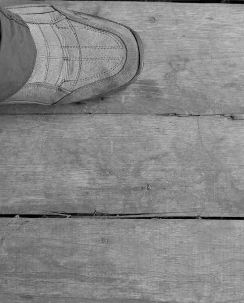 Zbliżenie: lewym bucie chodzenie na drewnianej podłodze. — Zdjęcie stockowe