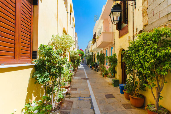 Rethymnon, Island Crete, Greece, - June 23, 2016: The narrow street of Rethymnon (part of Old Town) where there are a lot of pots with flowers