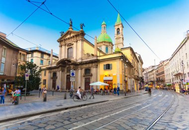 Milan, İtalya - 07 Eylül 2016: Görünüm Saint George Kilisesi (Chiesa San Giorgio al Palazzo), insanlar ve Milan tramvay akşam için raylar ile Arnavut kaldırımlı Torino sokak.