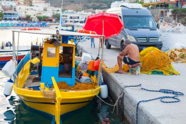 Bali, Island Girit, Yunanistan, - 30 Haziran 2016: balıkçı net yakınındaki balıkçı teknesi Köyü Bali Yunanistan Crete adada bulunan iskelede balık onarma.
