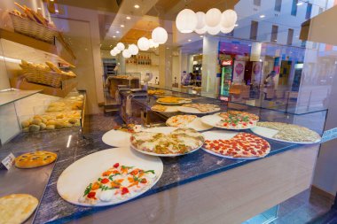 Milan, İtalya - 12 Eylül 2016: Lezzetli parçalarını pizza ve sokak pizzacı penceresinde cam Milano ve yansıma cam Caddesi'nin arkasında lezzetli çeşitler