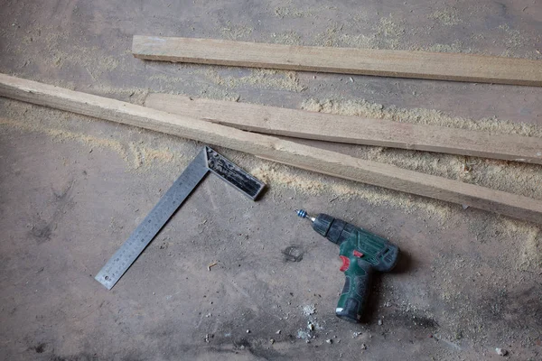 Matkap ile elektrik perforator kirli ve tozlu ahşap zemin üzerinde sırasında yenileme, yenileme ve Daire İnşaatı altında olduğunu.