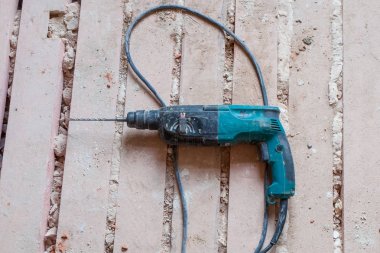 Kirli ve tozlu ahşap zemin üzerinde sırasında yenileme, yenileme ve Daire İnşaatı altında elektrik perforator (matkap) olduğunu.