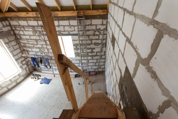 Wnętrze apartamentu w ramach remontu, przebudowy i budowy (drewniane schody na pierwsze piętro) i ubrań — Zdjęcie stockowe