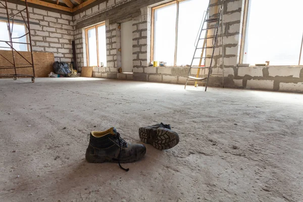 Wnętrze apartamentu w ramach remontu, przebudowy i budowy (parę butów roboczych na posadzki cementowe) — Zdjęcie stockowe