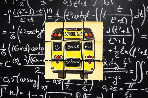 다시 학교 배경 제목에 "다시 학교"를 "학교 버스" 초 크에 의해 작성 된 수학 수식 노란색 칠판에 종이 조각에 서 면 — 스톡 사진
