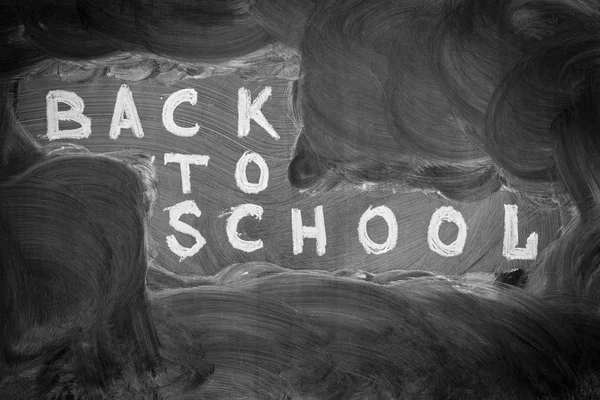 回到学校背景与标题 回到学校 白色粉笔写的黑色黑板和白垩渍擦除 — 图库照片