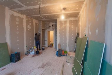 Alçıpan (plasteboard, alçı taşı) ve iç daire tadilat ve inşaat sırasında malzemelerle tadilat nedeniyle işçi duvarları hazırlar.