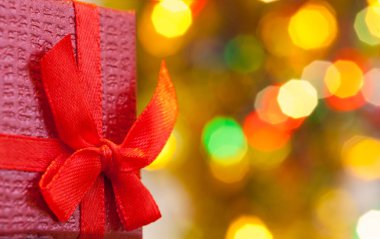 Kırmızı kurdeleli Noel hediyesi kutusu ve soyut tatil arkaplanı.