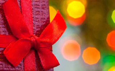 Kırmızı kurdeleli Noel hediyesi kutusu ve soyut tatil arkaplanı.