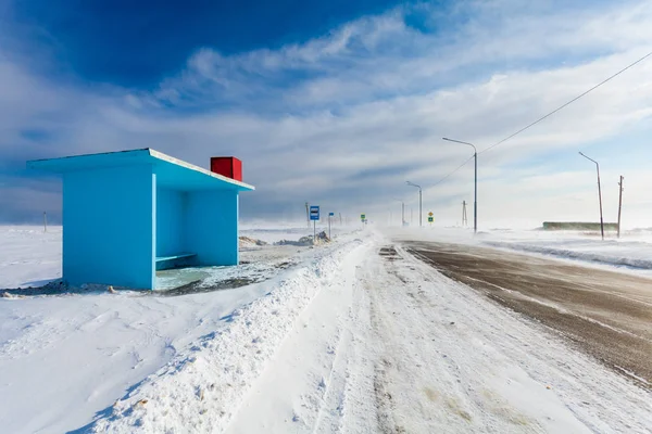 Peligrosa carretera de niebla con parada de autobús vacía y señales de tráfico en las zonas rurales para conducir coches y transporte público durante la tormenta de nieve o ventisca . — Foto de Stock