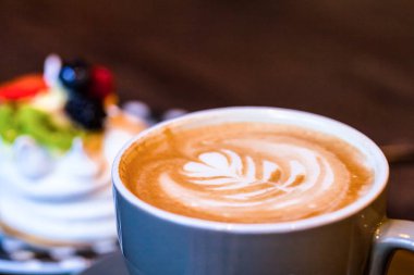 Ahşap masa ve bulanık çok kolay kahve latte sanat arka planda meyve ile