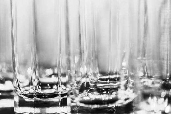 Black and white image of the a lot of glasses for beverages as abstract background — Stock Photo, Image