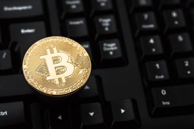 Klavye üzerinde Bitcoin. Fiziksel bit sikke. Dijital para. Cryptocurrency. Bitcoin simgesi olan altın sikke.